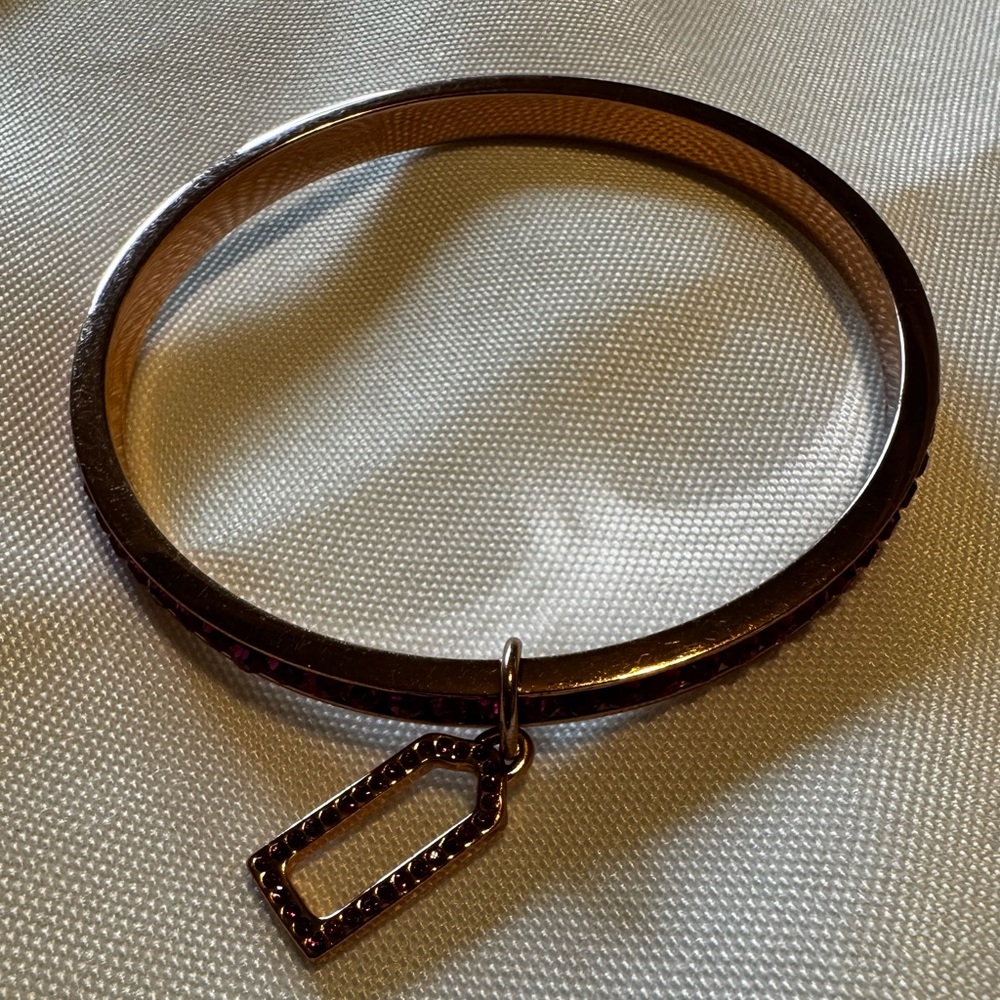 Coach rose gold bracelet with fushia stones.